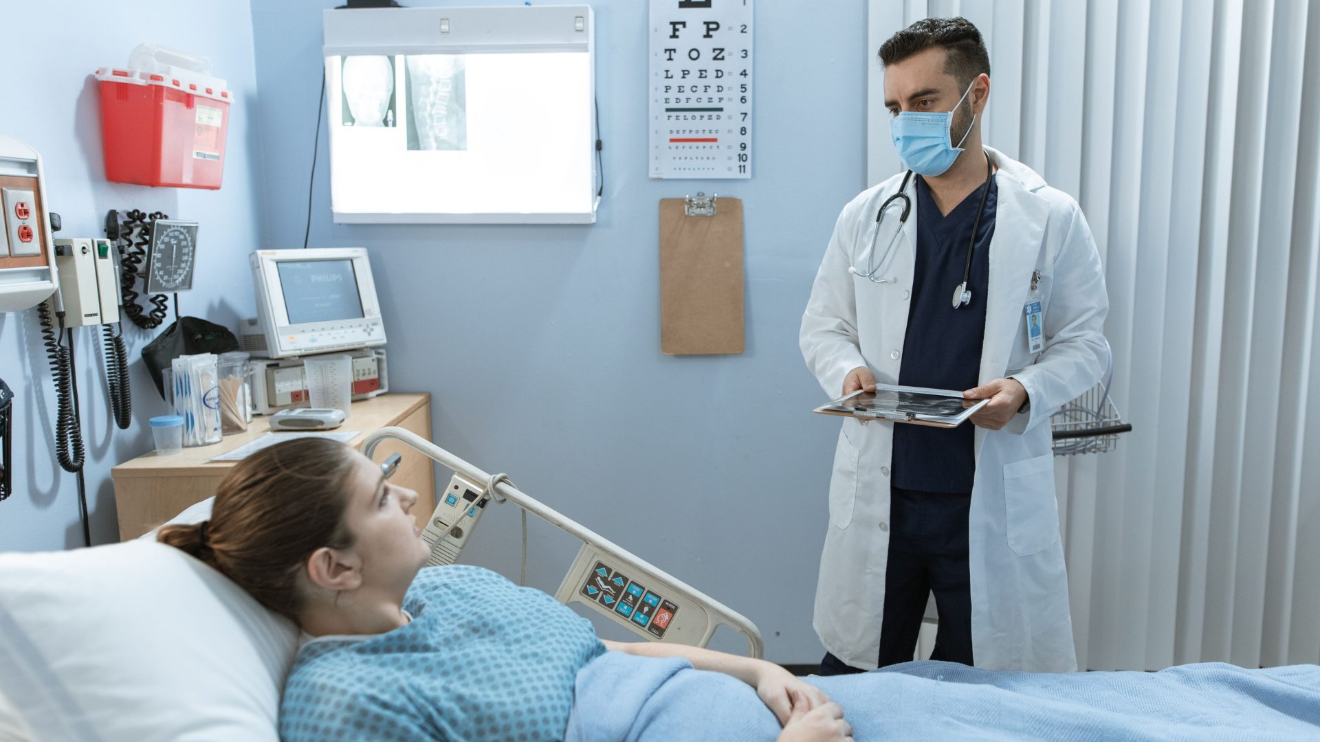 Arzt bespricht die Behandlung mit einer Patientin im Krankenhausbett